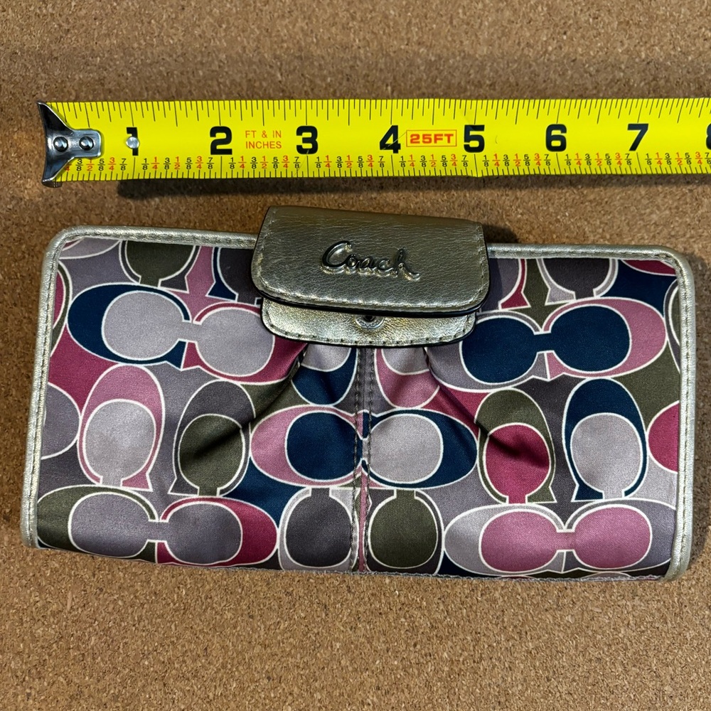 USED Coach wallet. Fold/snap closure. Zipped coin pocket. Shows wear. Colorful